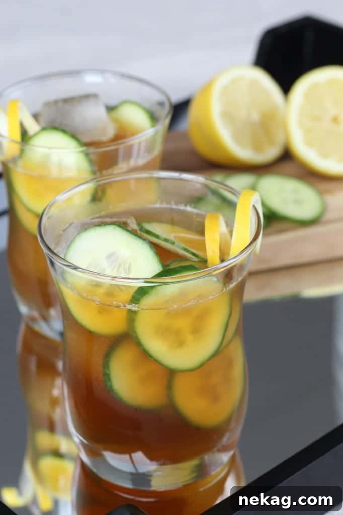 Close-up of a beautifully garnished Pimm's Cup, highlighting the freshness of the cucumber and lemon.