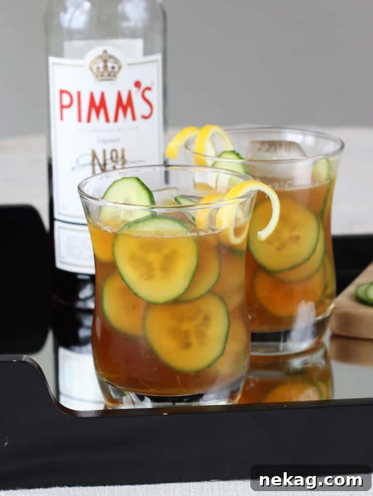 Two glasses of Pimm's Cup, elegantly garnished, ready for a toast.