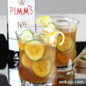 A close-up of a refreshing Pimm's Cup garnished with cucumber and lemon.