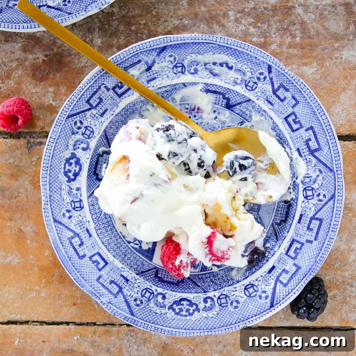 Served berry trifle portion on a beautiful blue vintage plate, showcasing layers.