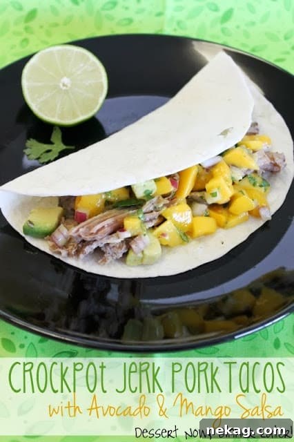Crockpot Jerk Pork Tacos with Avocado & Mango Salsa, served on soft tortillas.