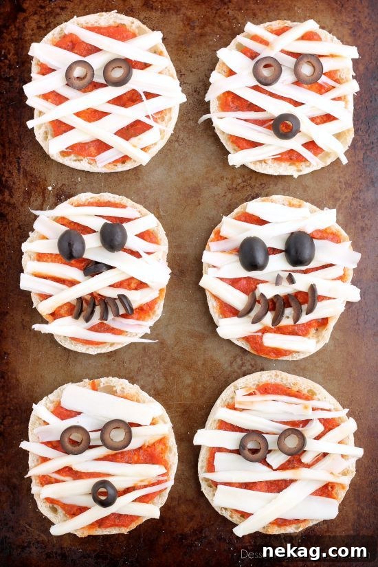 Spooky Swaddle Pizzettes 2 Mini Mummy Pizzas arranged on a black background, perfect for Halloween fun.
