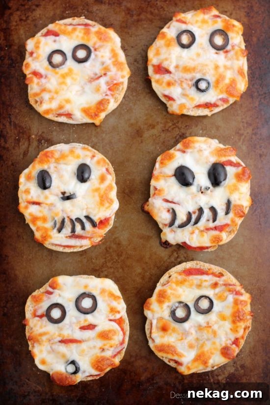 Spooky Swaddle Pizzettes 7 A finished Mini Mummy Pizza showcasing a variety of expressions using black olive slices.