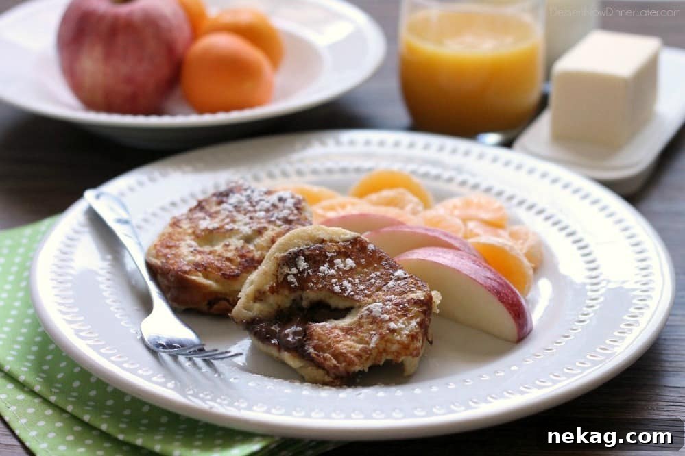A close-up of Chocolate Stuffed French Toast being cooked on a griddle, showing the golden-brown crust and a hint of the chocolate filling.