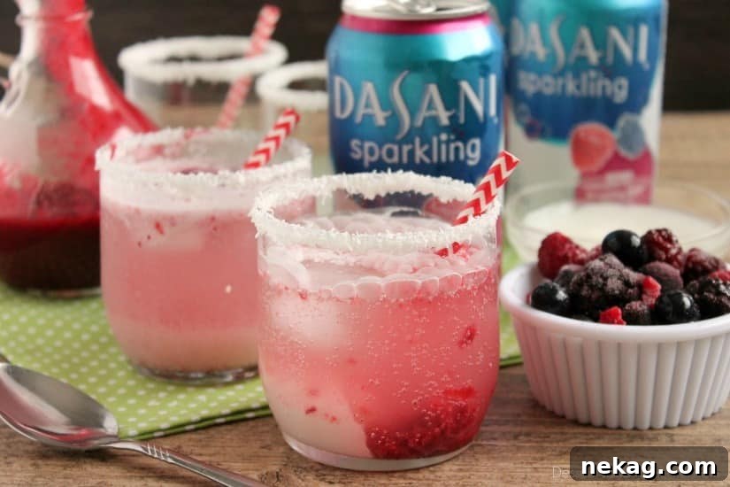 Close-up of Berry Coconut Spritzer ingredients: a bowl of frozen mixed berries, a can of DASANI Sparkling Water, and a jar of cream of coconut.