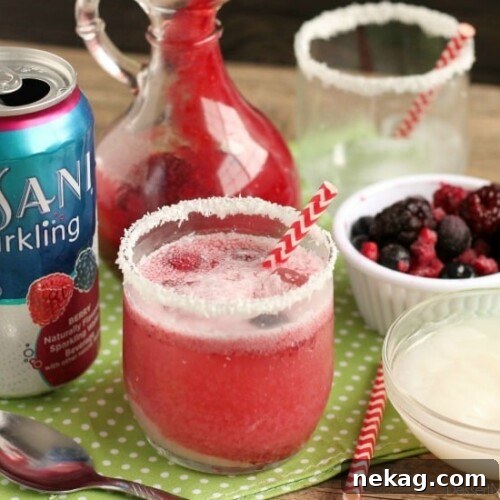 A beautifully presented Berry Coconut Spritzer, ready to be enjoyed as a festive mocktail.