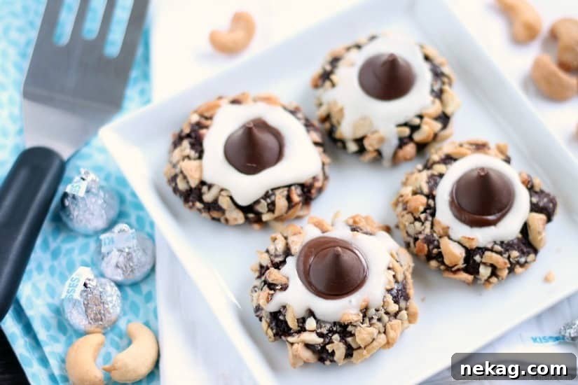 Creamy Chocolate Thumbprint Delights 3 Close-up of a Chocolate Cream Thumbprint Cookie showcasing the nut-covered edge and a glossy chocolate kiss.