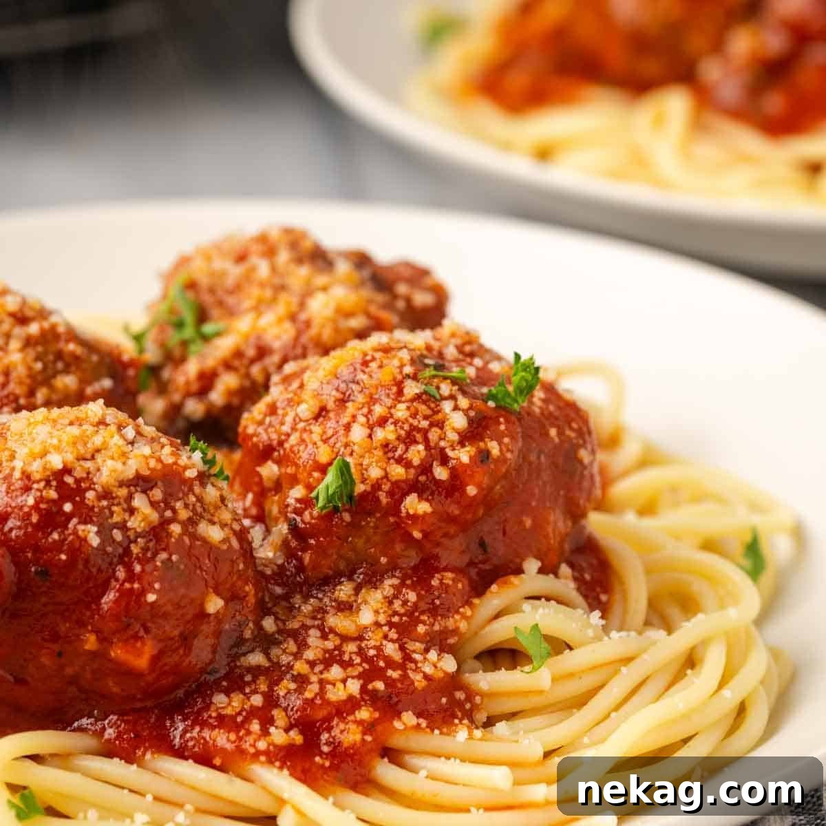 Cloud-Like Ricotta Meatballs 11 A serving of spaghetti and perfectly cooked ricotta meatballs, generously coated in red sauce and garnished with fresh herbs.