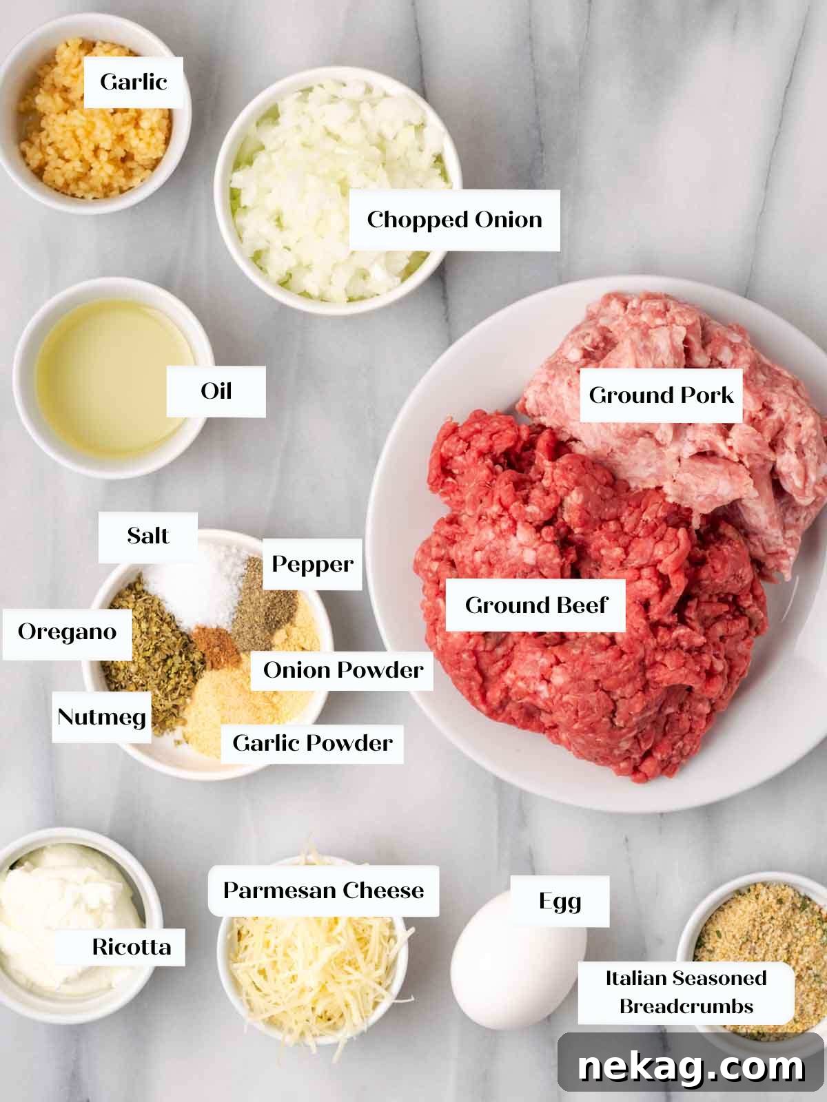 Cloud-Like Ricotta Meatballs 3 A collection of fresh ingredients for ricotta meatballs laid out on a marble countertop: garlic, onion, olive oil, ricotta, ground meat, parmesan, oregano, garlic powder, onion powder, pepper, nutmeg, salt, egg, and breadcrumbs.