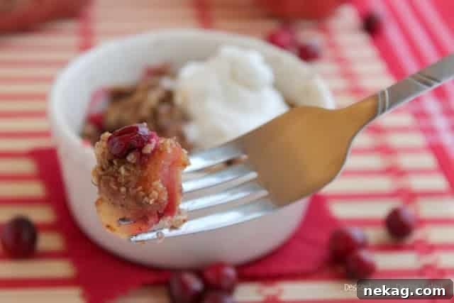 Sliced sweet apples and fresh cranberries mixed in a bowl, ready for the crisp.