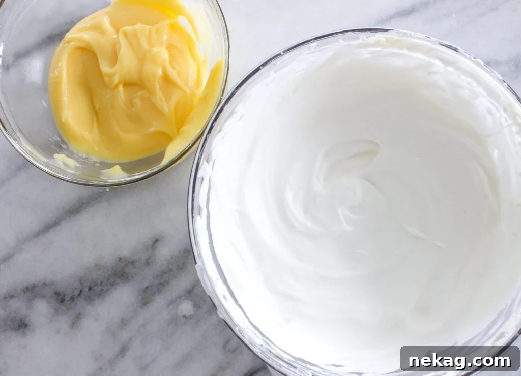 Zesty Lemon Cream Delight 3 A bowl of creamy lemon whipped cream with a spatula, showcasing its perfect texture.