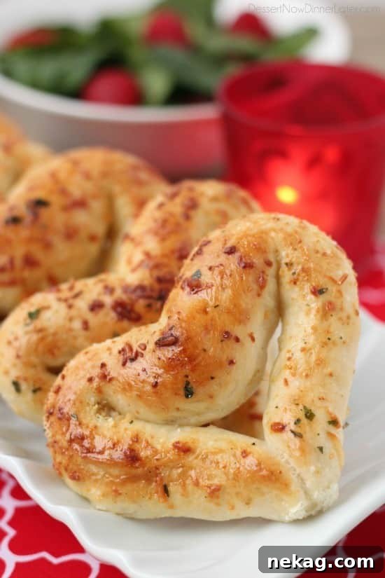 Close up shot of a single perfectly baked heart shaped breadstick, showcasing its golden crust and delicious texture.