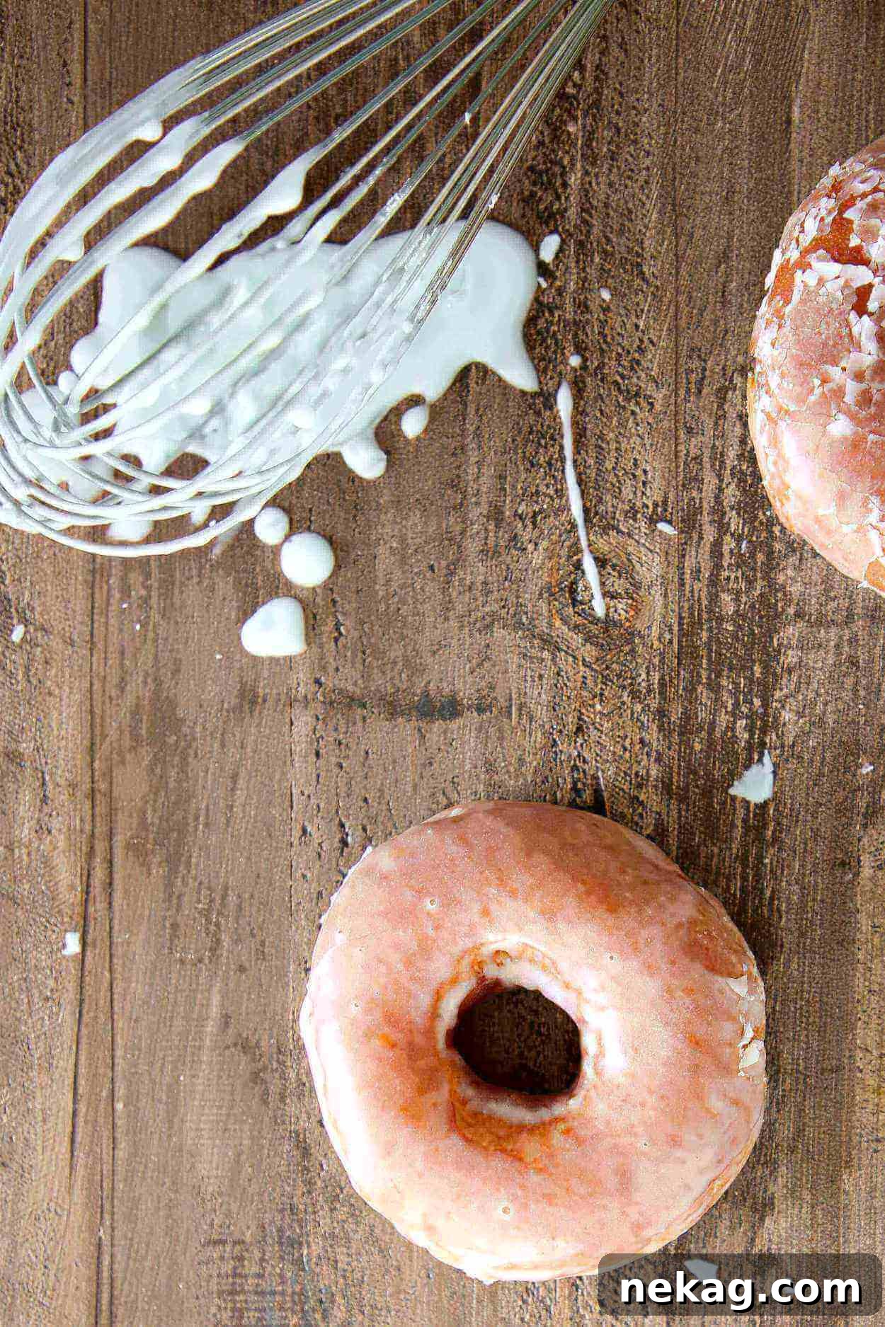 Irresistibly Delicious Donut Glaze 2 A whisk dripping sweet, classic donut glaze onto a rustic wooden surface, highlighting the perfect consistency for homemade donuts.