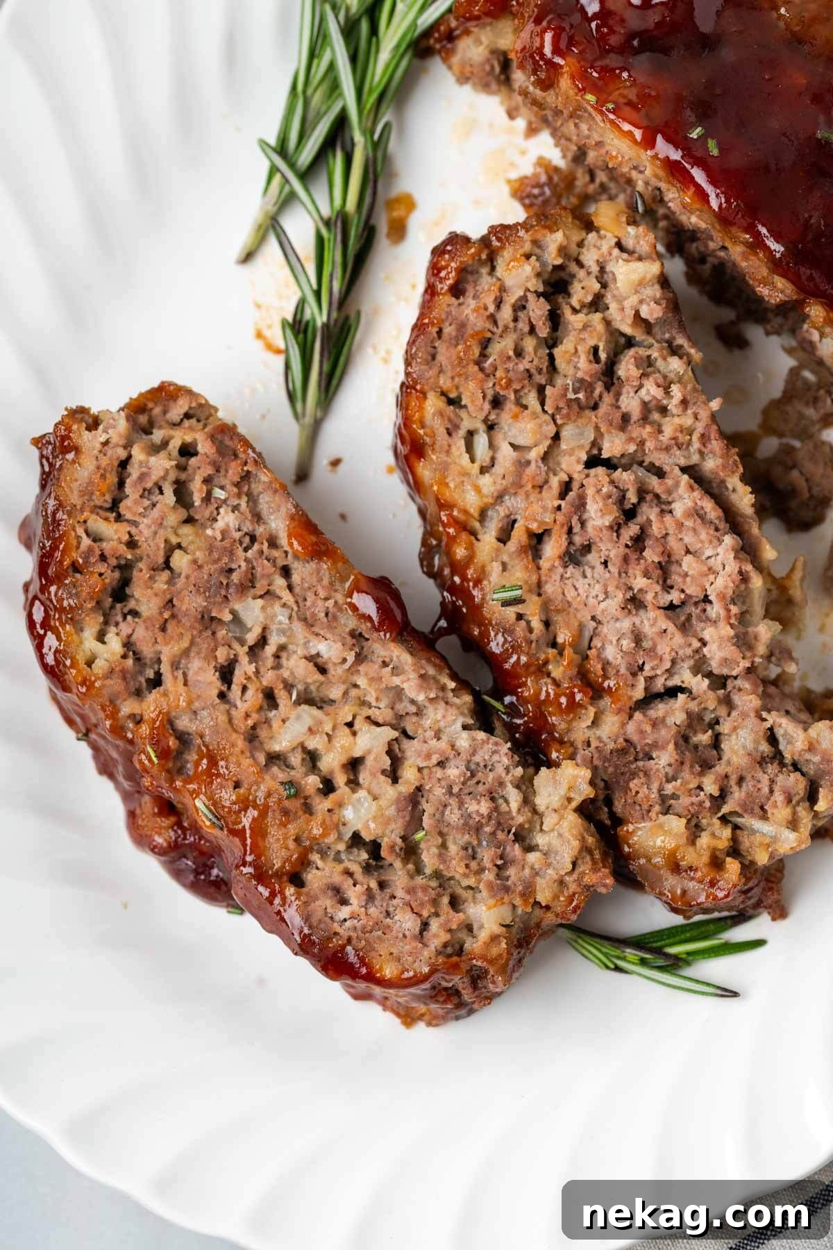 Sweet and Sticky Brown Sugar Meatloaf 10 brown sugar meatloaf sliced on plate with rosemary.