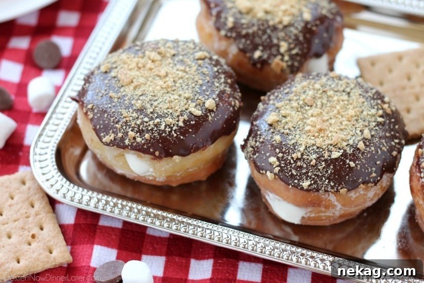 Glazed and ganached, with crushed graham crackers on top, and a marshmallow buttercream center, these S'mores Donuts are delicious and decadent.
