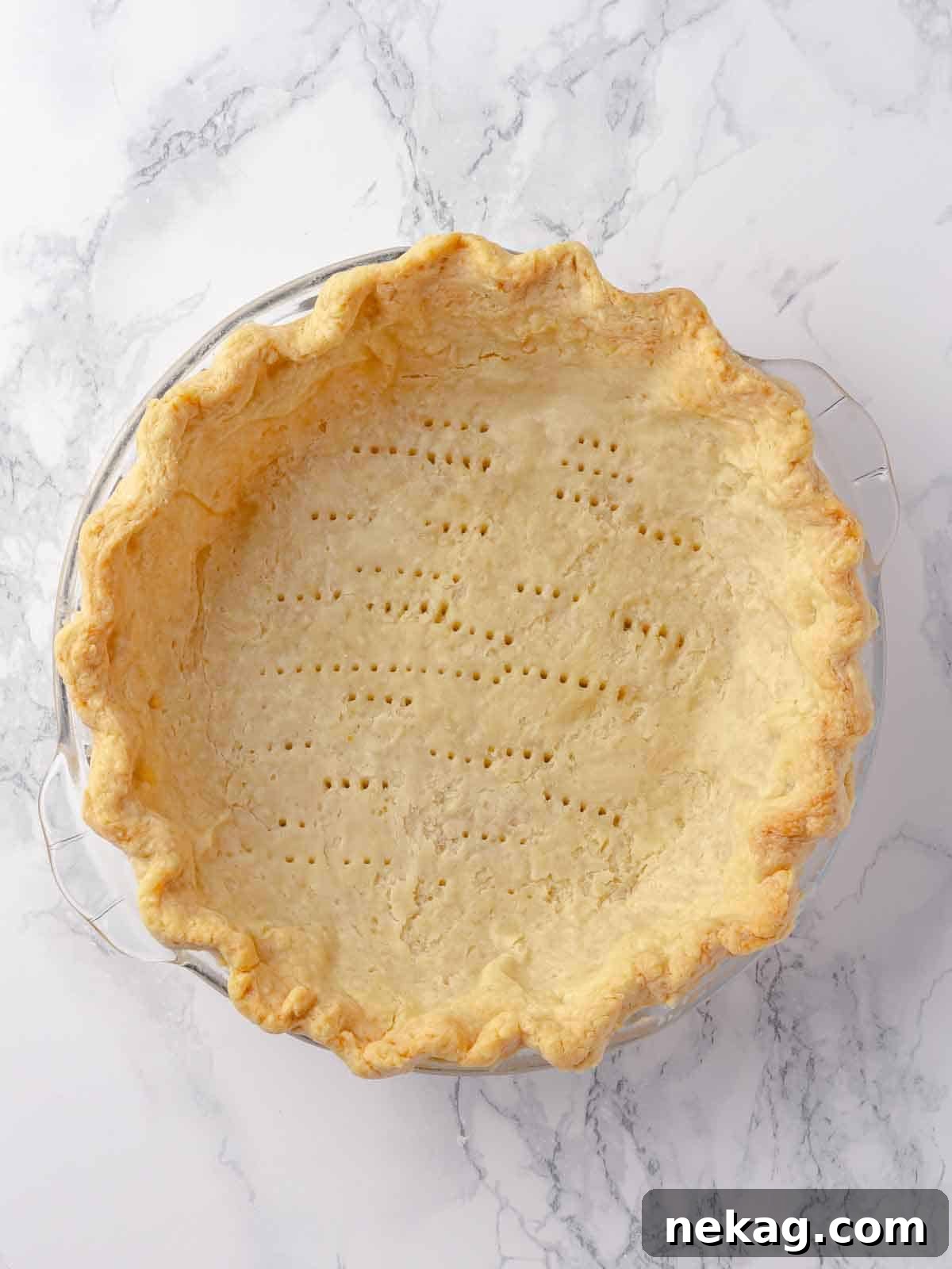 Blind-baked Pâte Sucrée, docked and golden brown, ready for filling.