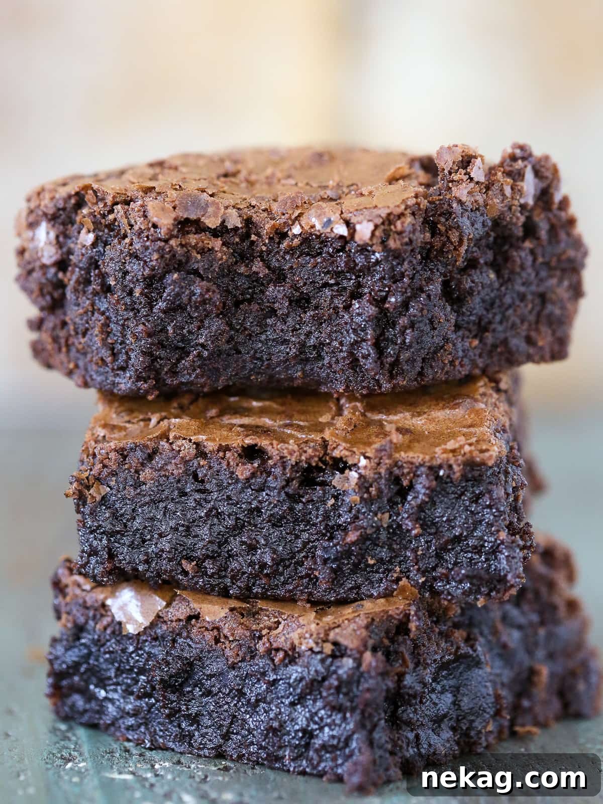 Ultimate Fudgy Brownie Perfection 2 A small stack of gooey brownies revealing deep chocolate color and soft texture between layers.