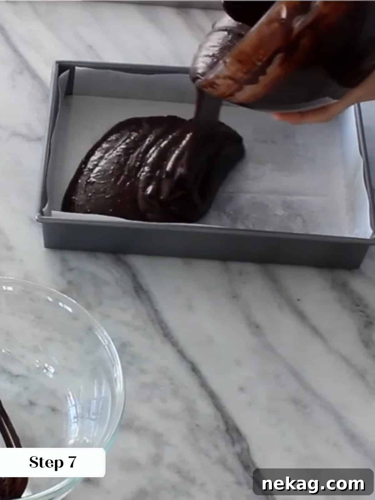 Ultimate Fudgy Brownie Perfection 12 Pouring thick brownie batter into a parchment-lined baking pan before placing it in the oven.