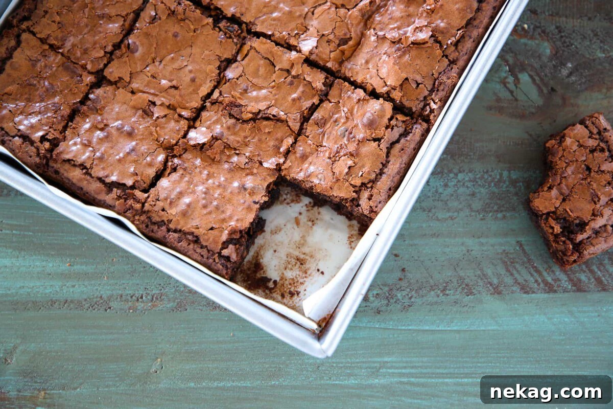 Ultimate Fudgy Brownie Perfection 5 Freshly baked fudgy brownies resting in a metal pan, already to cut into squares.