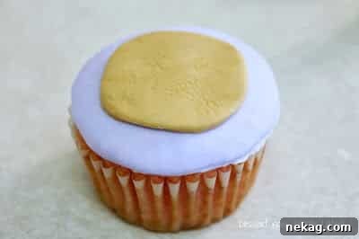 Brown fondant circle adhered to the purple base, creating the monkey's muzzle.