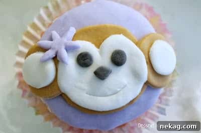 Finished girl monkey cupcake with a drawn mouth, completing the cheerful expression.
