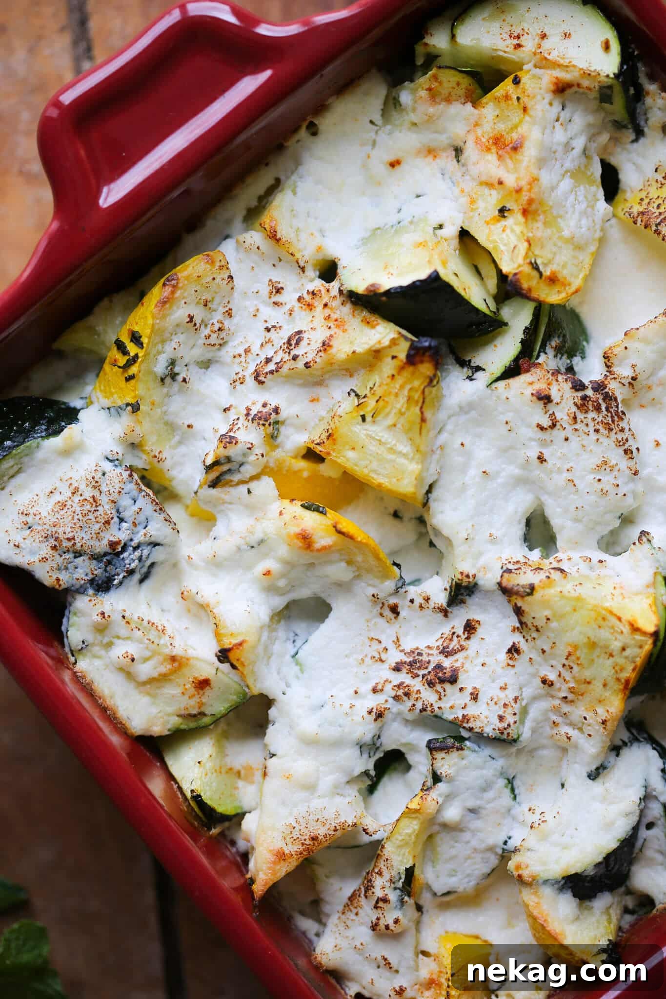 Top view of golden brown Baked Zucchini and Ricotta Casserole, garnished with fresh herbs