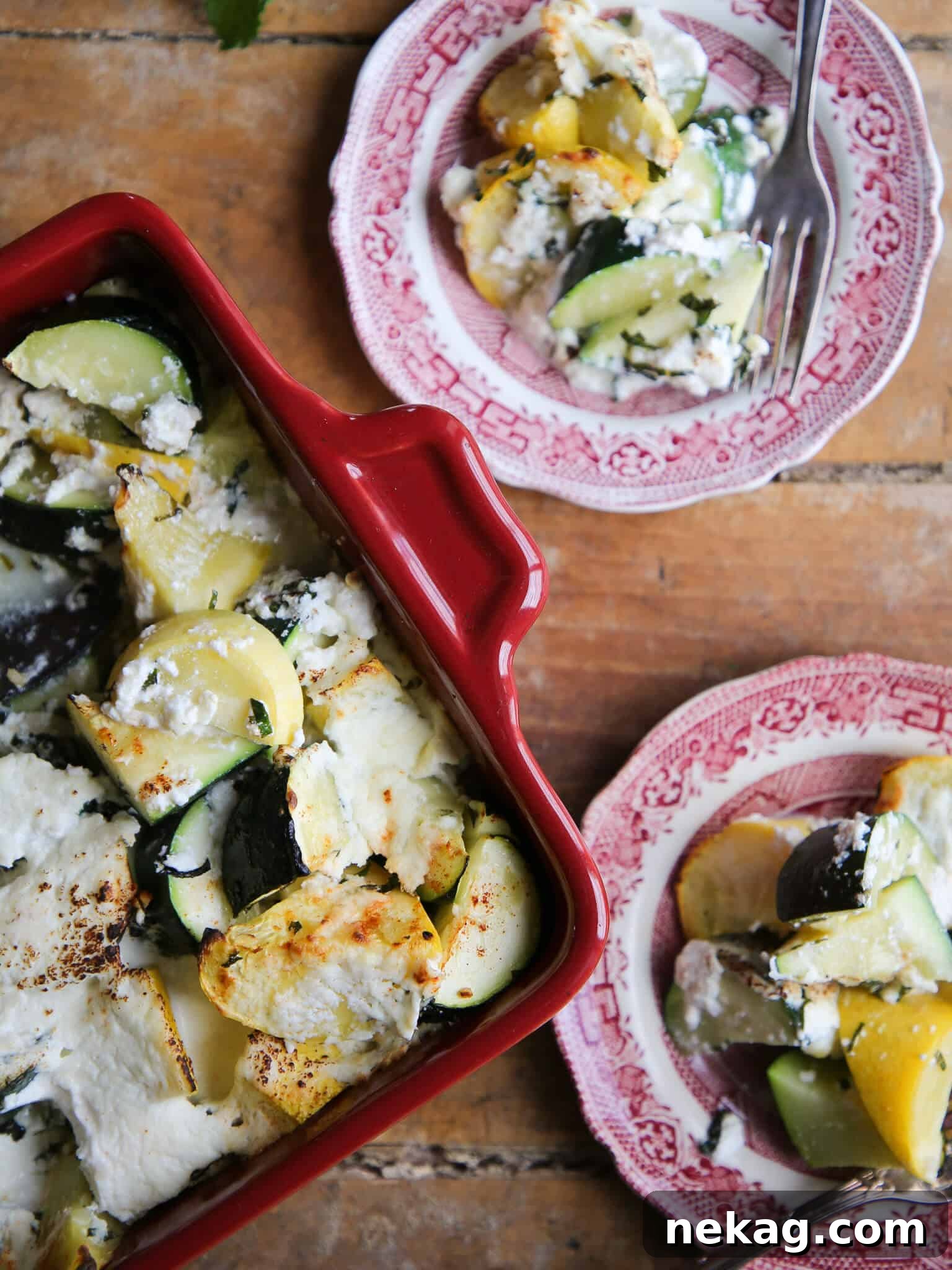 Zucchini Ricotta Casserole featured on a rustic tablescape with red ceramic plates