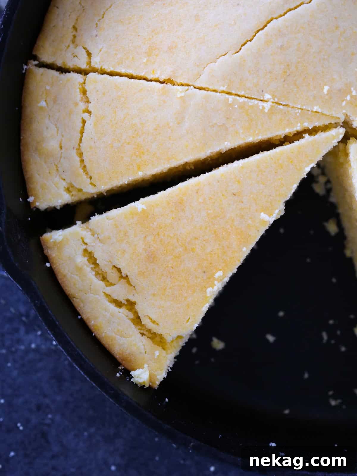 sliced southern cornbread in black cast iron skillet golden top.