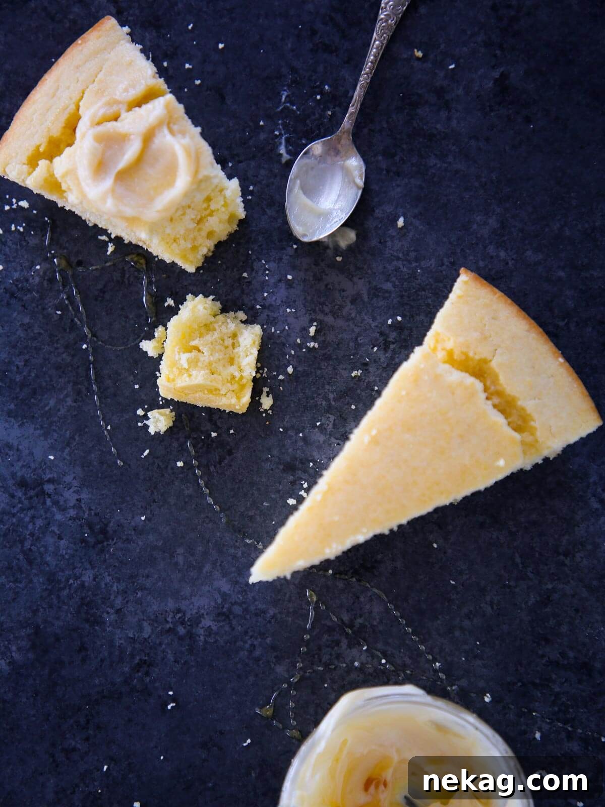 blue surface with two slices of cornbread and butter and honey drizzle.