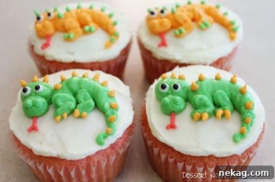 A tray of beautifully decorated dragon cupcakes, ready for a party.