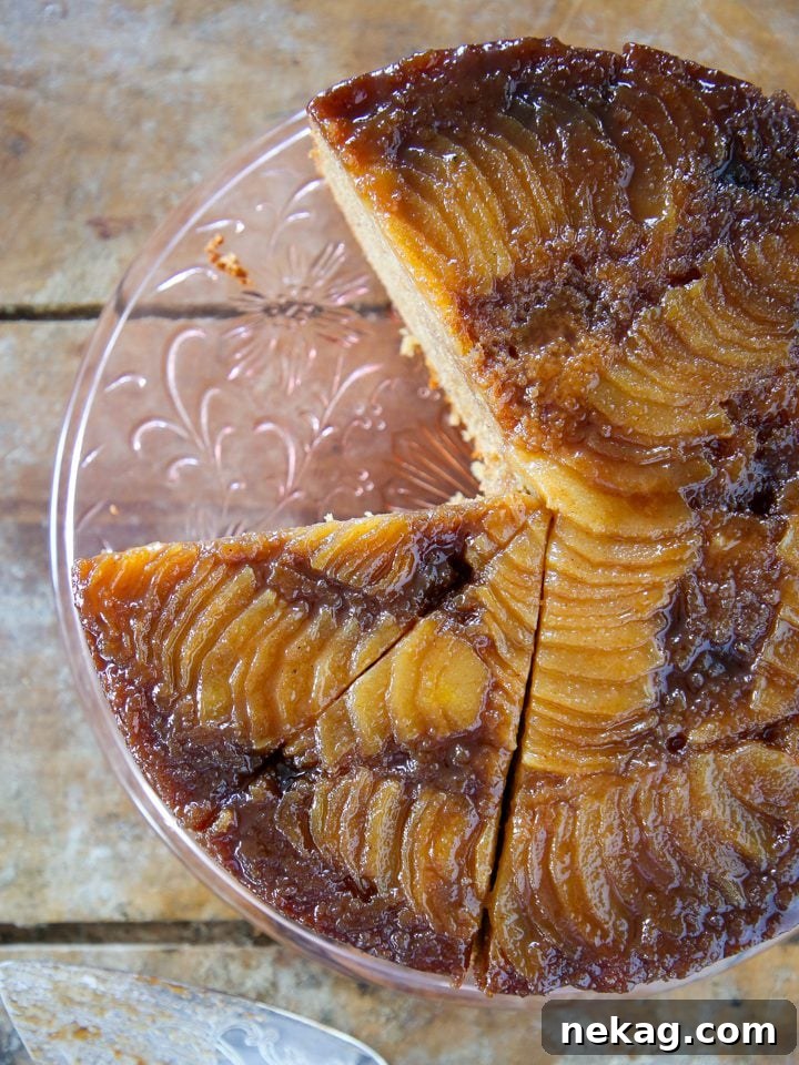 Golden Pear Flip Cake 2 Pear upside down cake on clear cake stand, showcasing caramelized pears.