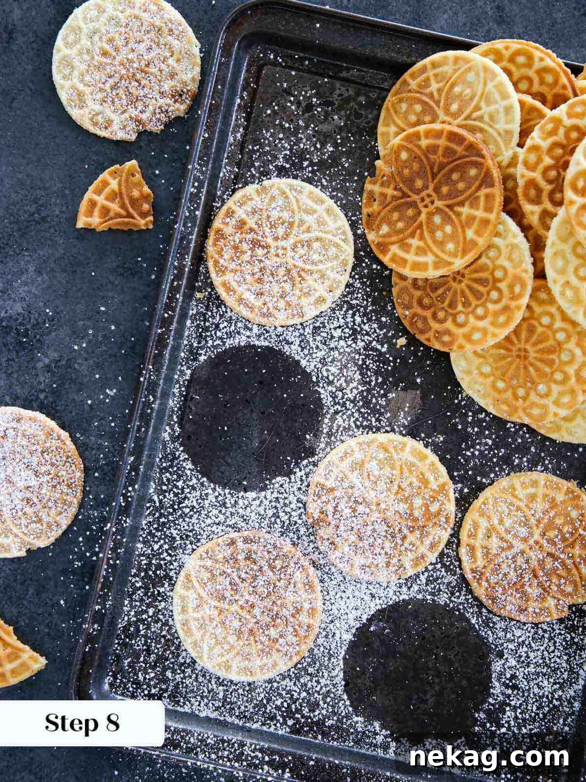 A cooked pizzelle cookie delicately dusted with powdered sugar, ready for serving.