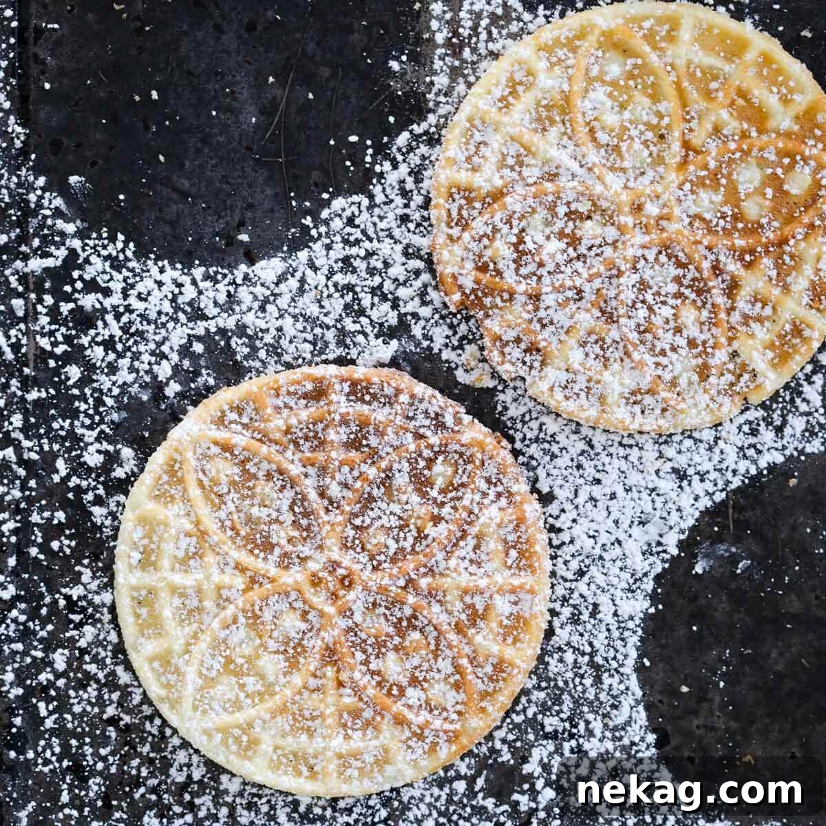 Pizzelle cookies lightly dusted with powdered sugar, creating a beautiful wintery effect.