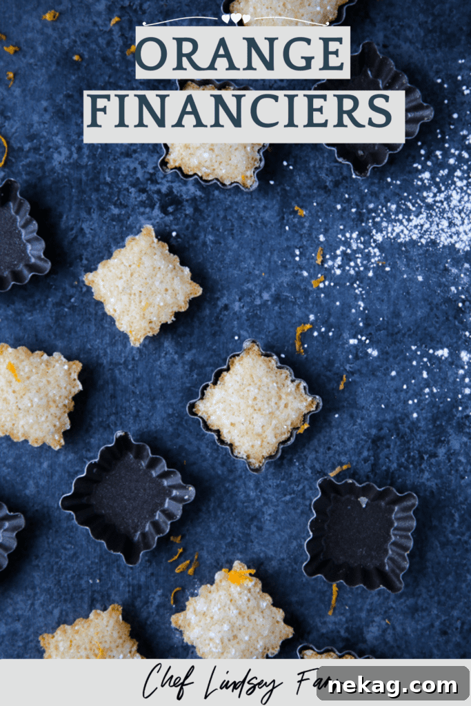 A stack of Orange Financiers dusted with powdered sugar