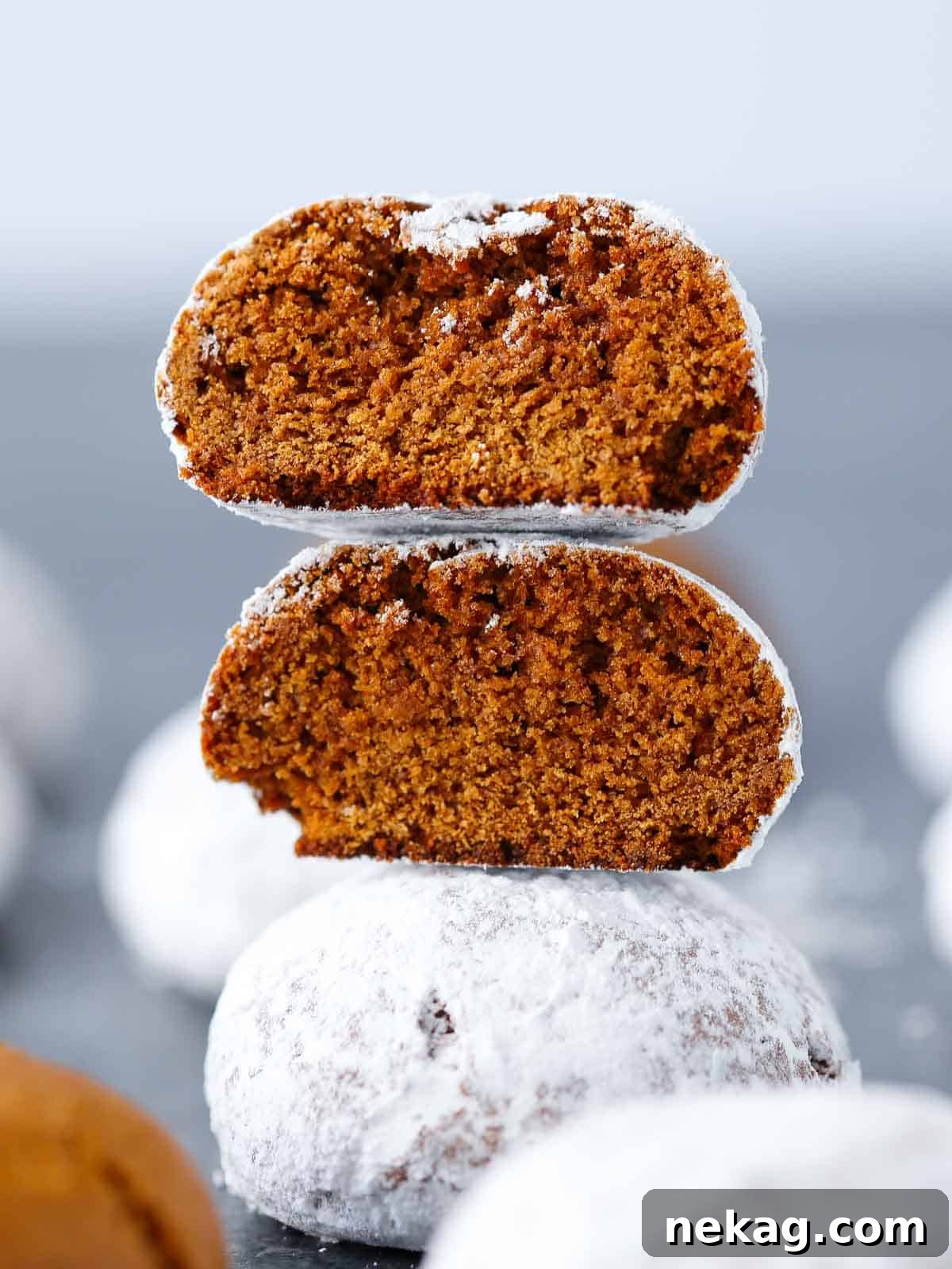 German Christmas Spice Cookies 2 Three stacked Pfeffernusse cookies, coated in powdered sugar.