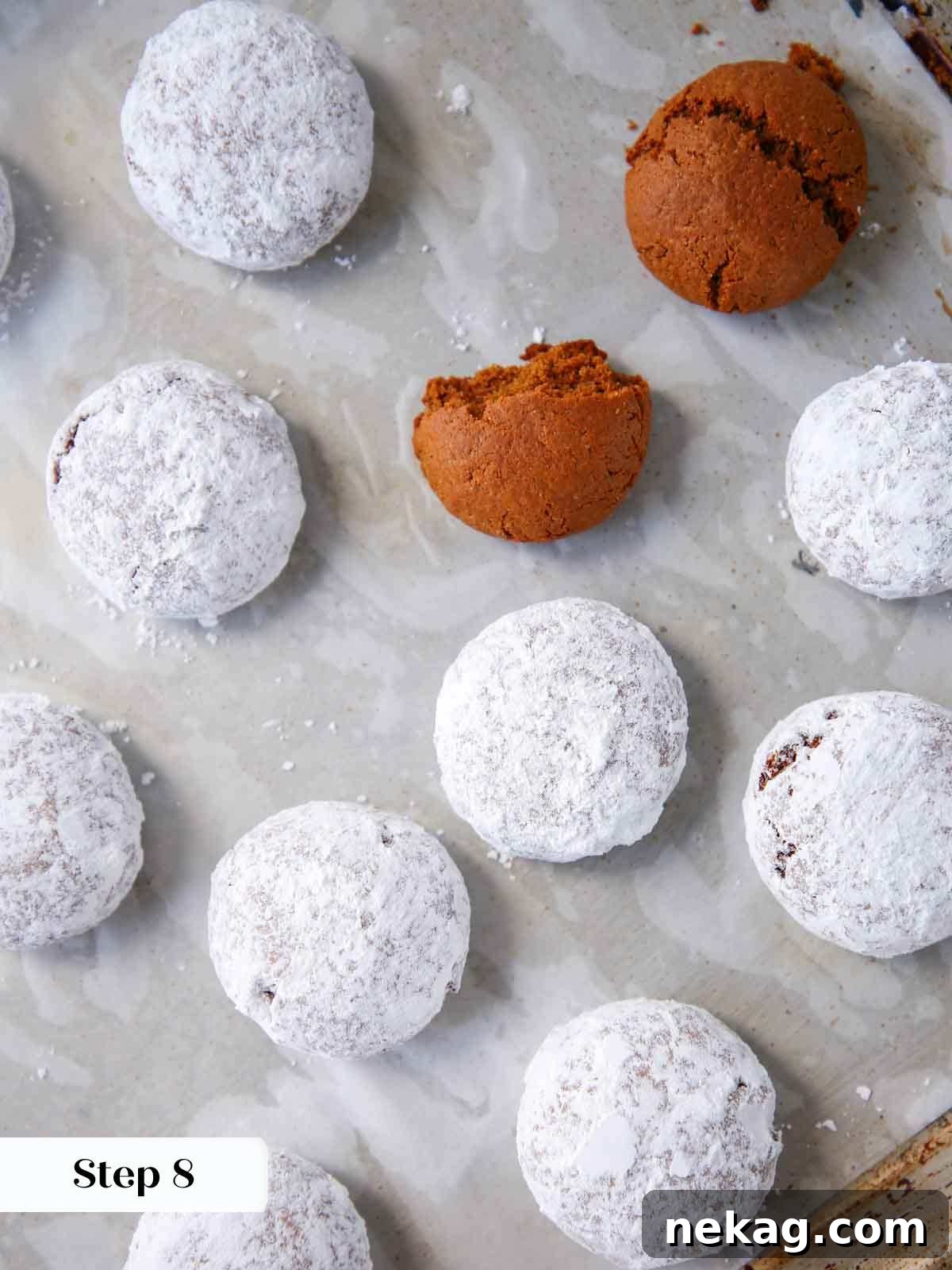 German Christmas Spice Cookies 10 Powdered sugar coated Pfeffernusse cookies on a tray.