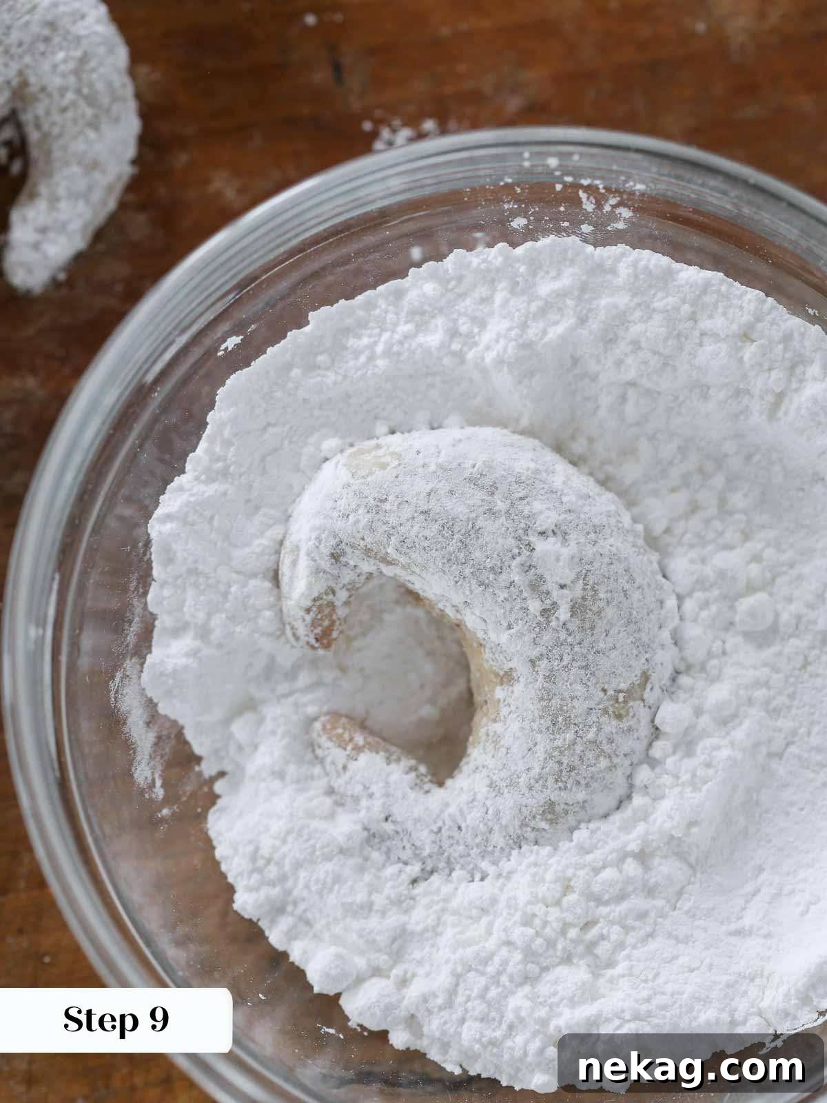 Buttery Almond Crescents 10 crescent cookie in powdered sugar bowl.