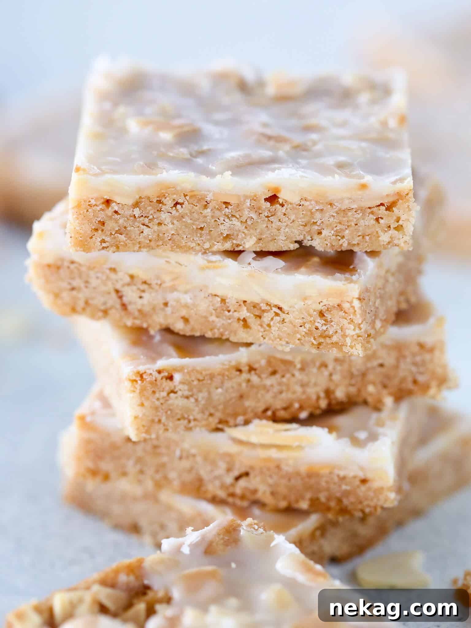 Irresistible Almond Bars 2 Crisp almond cookies stacked from the front, showcasing their golden-brown edges and frosted tops.