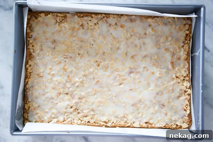Irresistible Almond Bars 3 Crunchy almond cookies uncut in a silver baking pan, showing the rich almond topping before glazing.