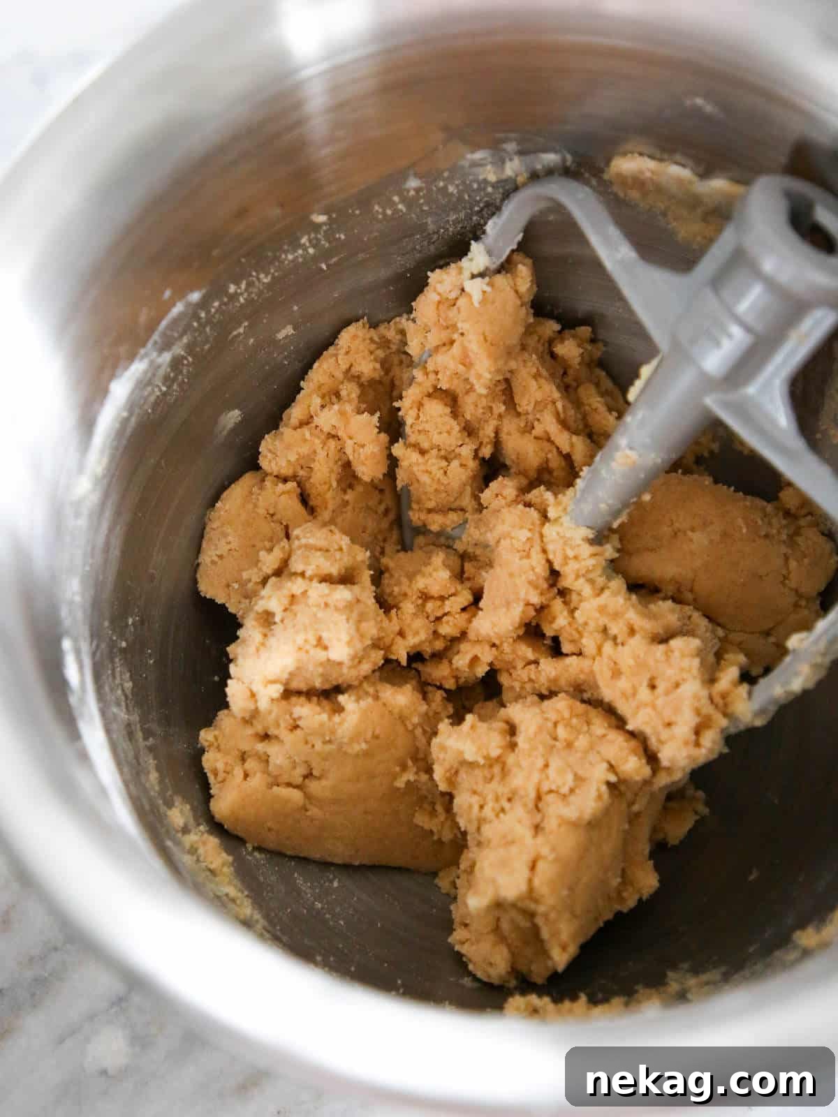 Irresistible Almond Bars 4 Cookie dough being mixed in a silver stand mixer bowl, showing the creamy texture.