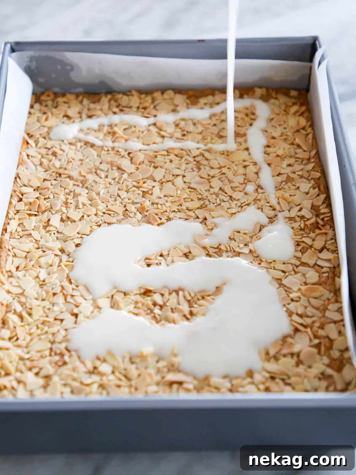 Irresistible Almond Bars 8 A pan of bar cookies with a beautiful, even white glaze drizzle pattern.