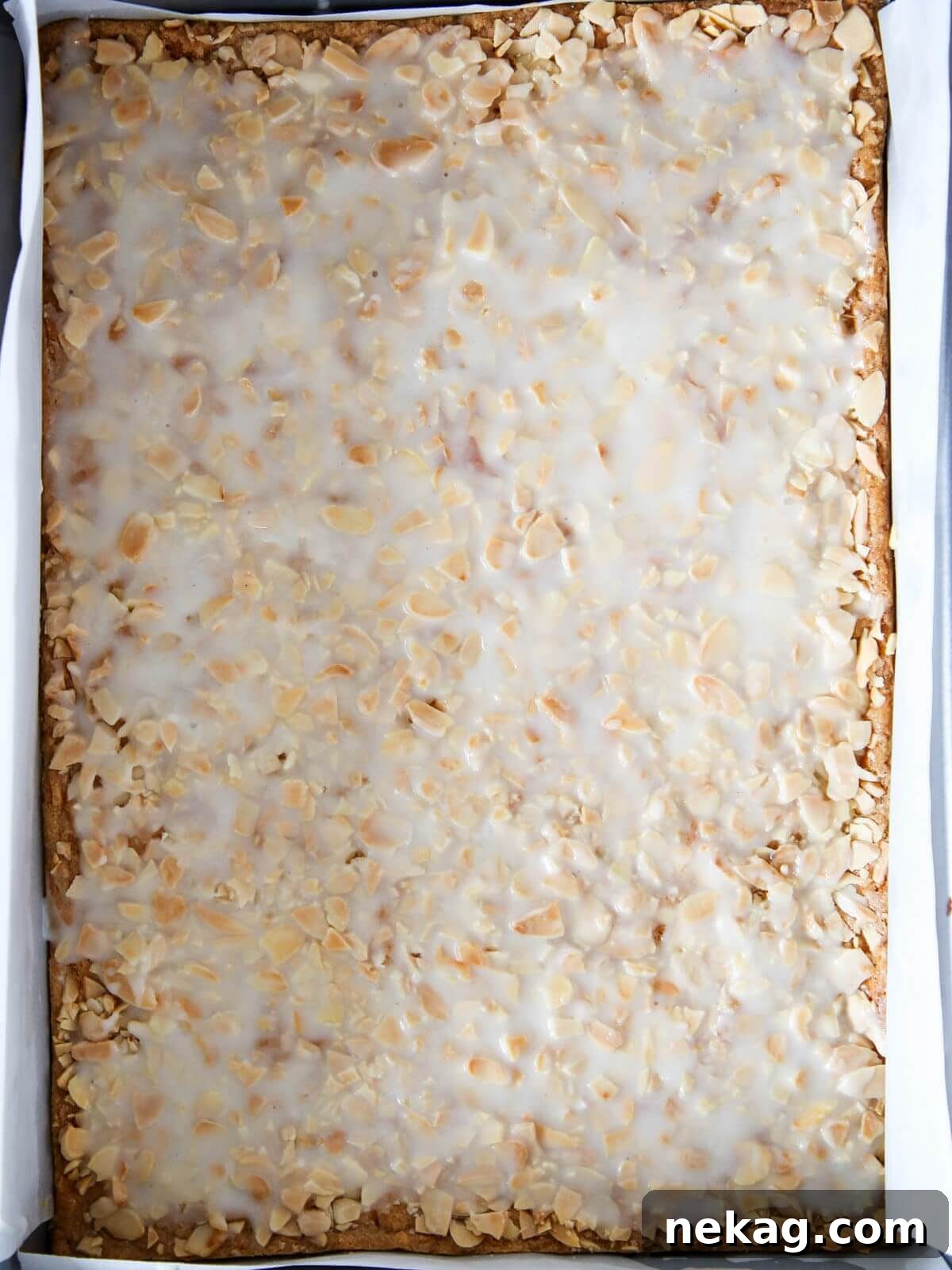 Irresistible Almond Bars 9 A pan of cookies with a perfectly spread white glaze over the almond topping, ready for cutting.