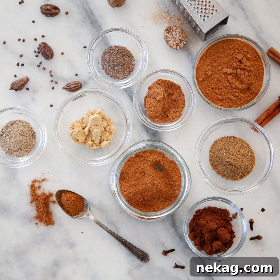 Speculoos Spice Mix in a jar with various whole spices around it