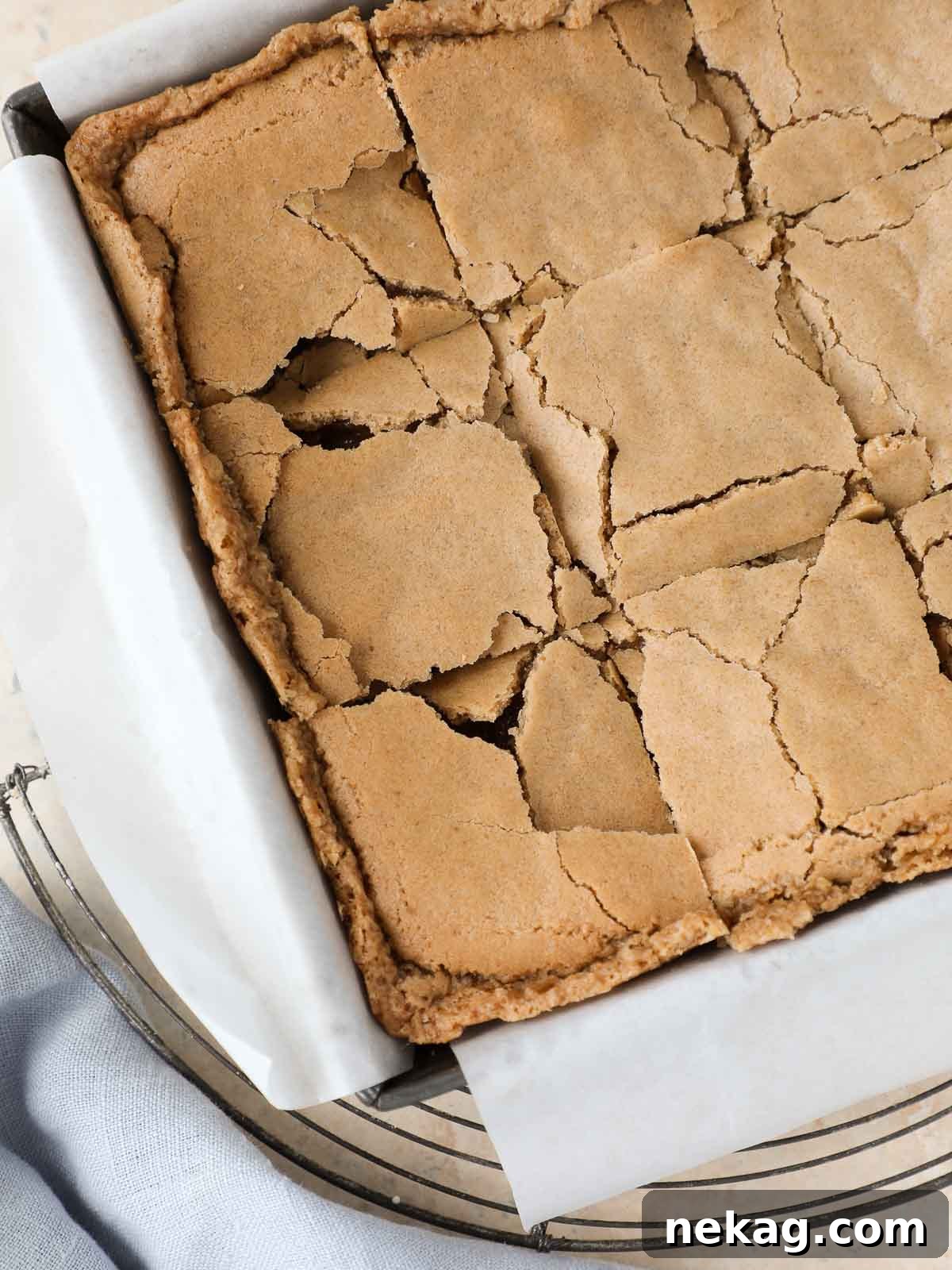 Sliced butterscotch brownies cooling in a pan on a wire rack.