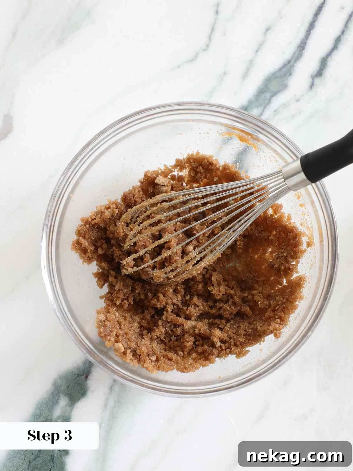 Whisking melted butter and sugar together in a bowl for brownies.