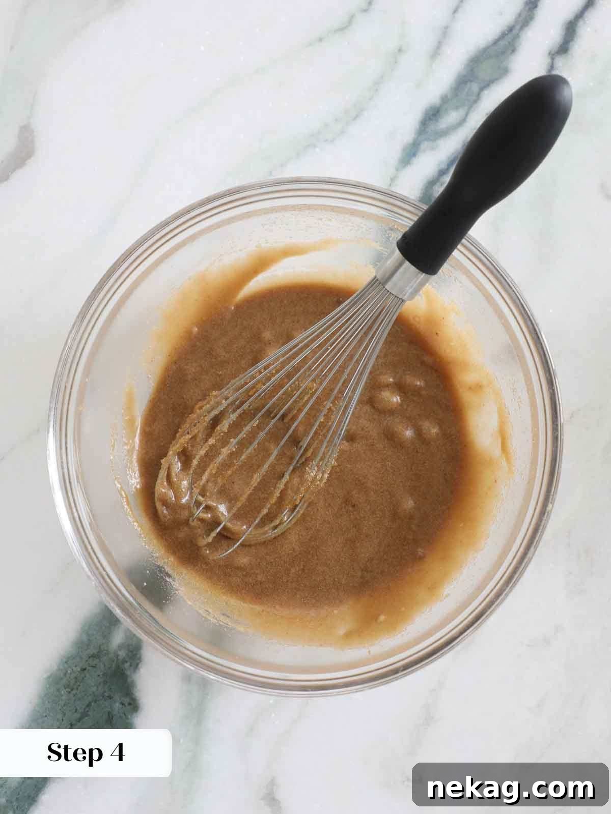 Wet ingredients (butter, sugar, eggs, vanilla) whisked smoothly in a bowl for butterscotch brownies.