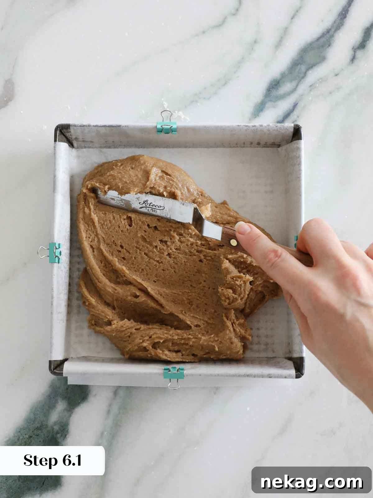 Spreading butterscotch brownie batter evenly into the prepared baking pan.