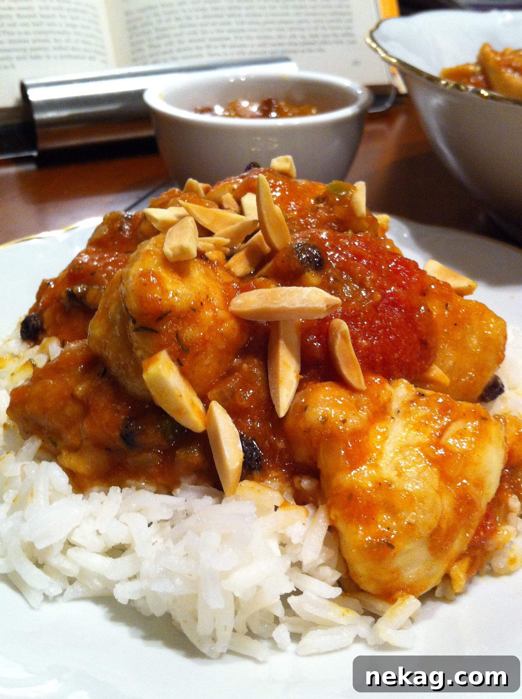 Country Captain: A Legendary Heritage Chicken Curry 2 A beautifully plated Country Captain Chicken Curry, garnished with almonds and chutney, served with rice.