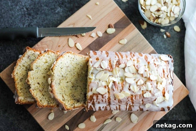Golden Almond Poppy Seed Loaf 4 A beautifully presented Almond Poppy Seed Loaf with a glistening glaze, adorned with sliced almonds on a rustic dark background.