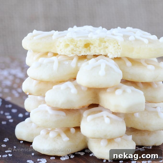 Soft sugar cookies shaped like snowflakes, artfully stacked on a plate.